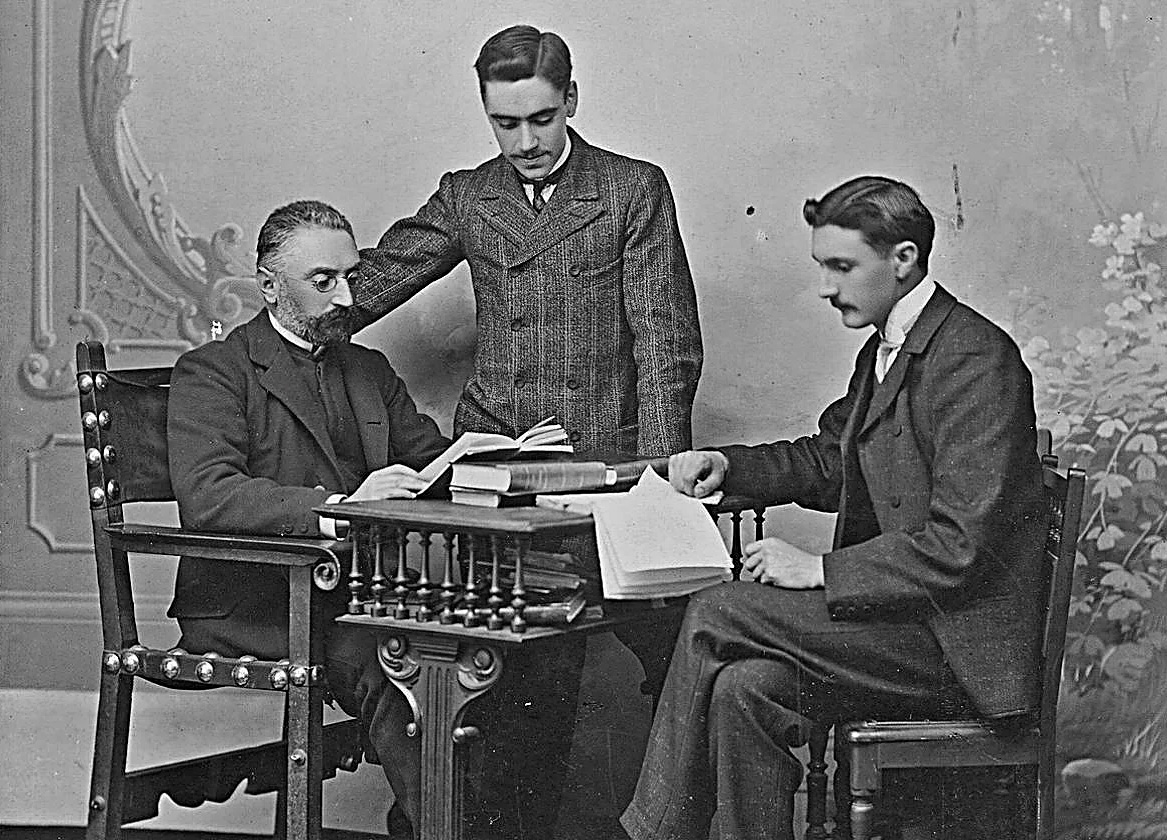 El magisterio vivo: Miguel de Unamuno junto a sus discípulos Federico de Onís (de pie) y Licinio Perdigón. Esta histórica fotografía de Venancio Gombau, dedicada por los alumnos a su maestro el 26 de mayo de 1905, custodia la memoria de una filiación intelectual única en los fondos de la Casa-Museo Unamuno (Universidad de Salamanca).